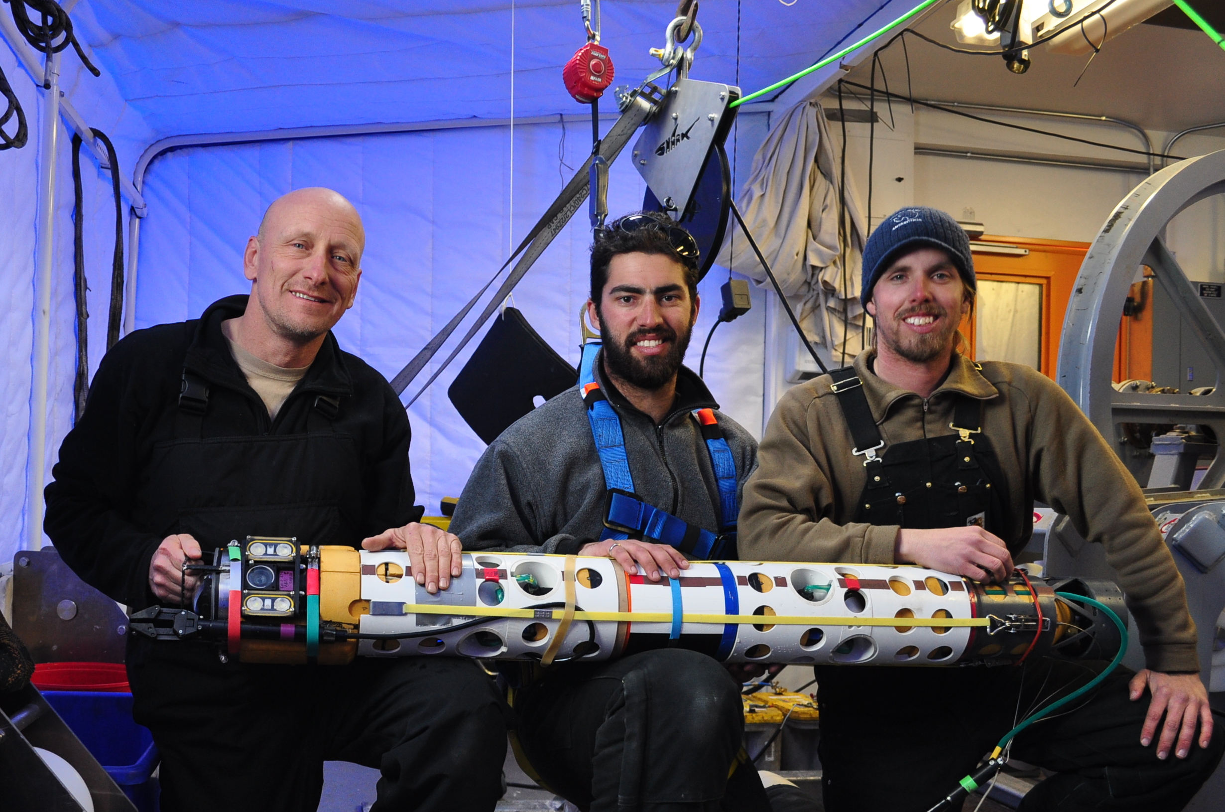 Robot deployment team engineers Bob Zook, Paul Mahecek, and Dustin Carroll, seen here holding the underwater robot that captured images of the ice anemones. Image credit: Dr. Frank R. Rack, ANDRILL Science Management Office, University of Nebraska-Lincoln.