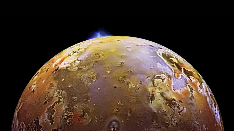 A blue geyser-like volcanic eruption at the edge of Io.