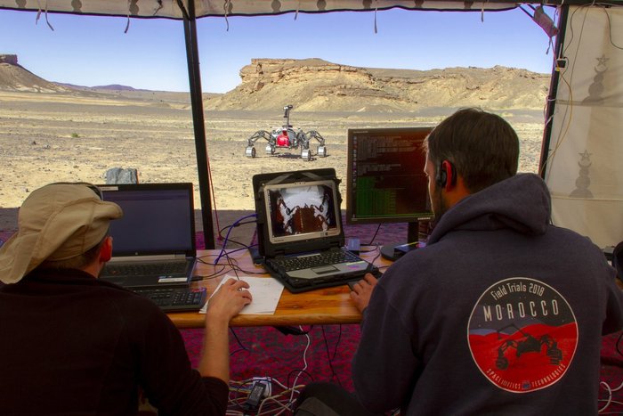 Engineers watch the progress of one of the test rovers in Morocco.