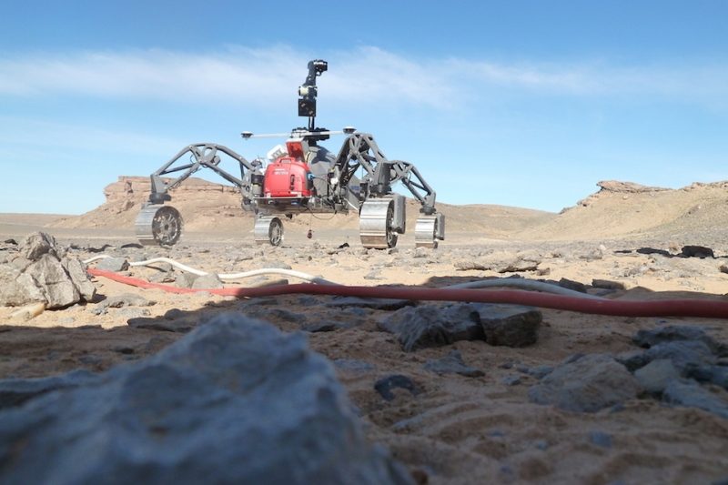 Spider-like, four-wheeled vehicles in a rocky landscape