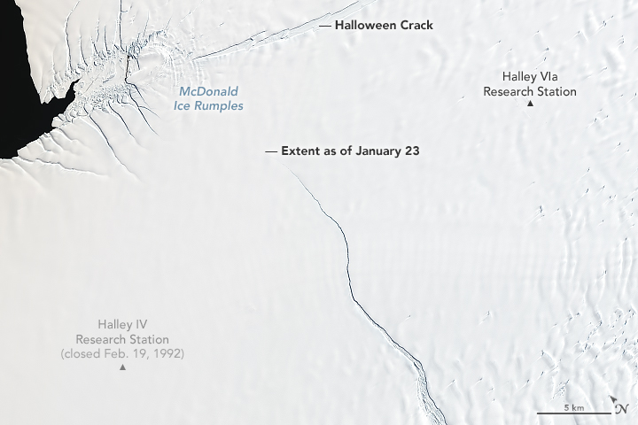 Close-up orbital view of ice shelf with large crack across it.
