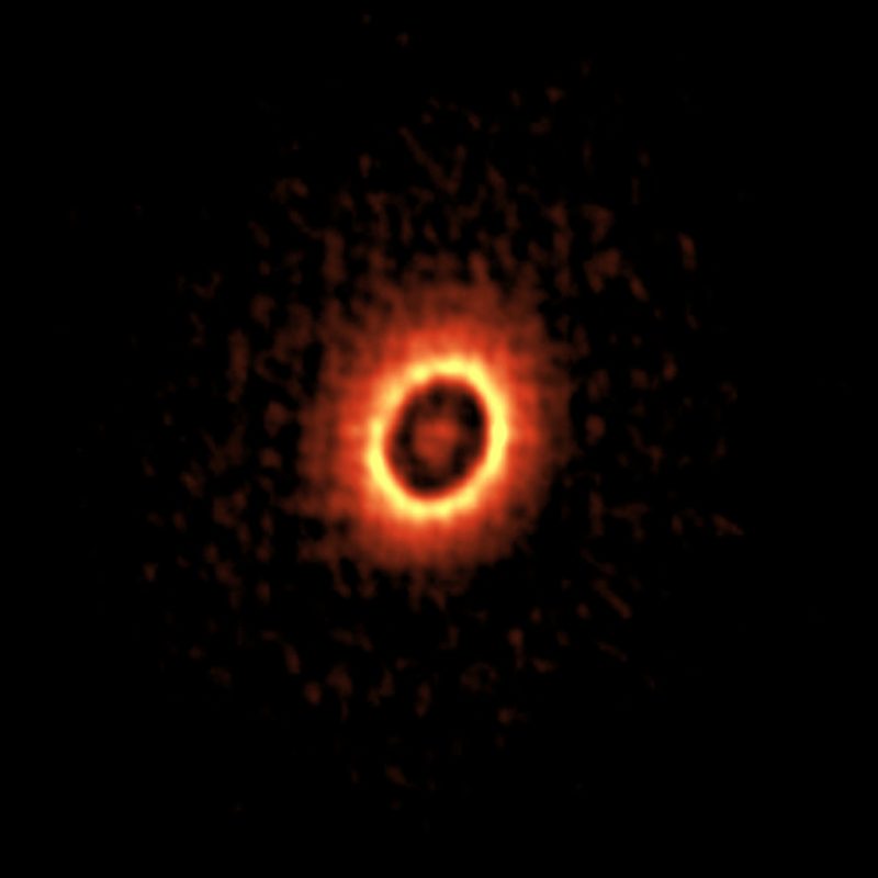 Fuzzy concentric rings, the inner one more distinct and brighter, around an orange dot.