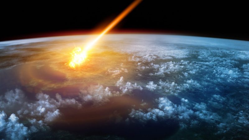 Earth from space with flaming asteroid descending through atmosphere.