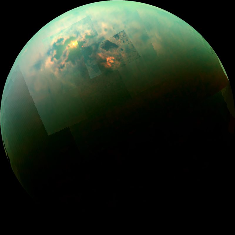 Round planet, mostly green, with scattered yellow and orange spot toward the top.