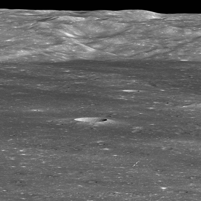 Moon landscape with mountains on horizon and craters closer to observer.