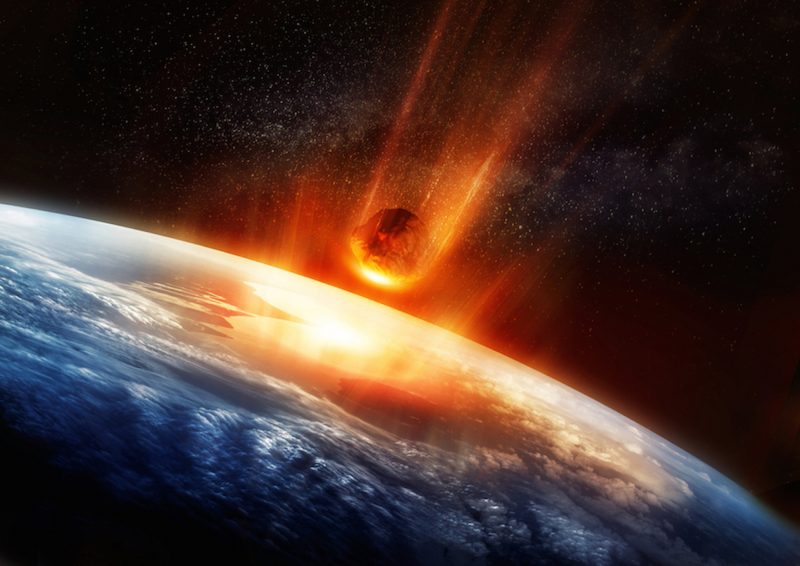 Glowing asteroid with orange tail rushing downward toward Earth.