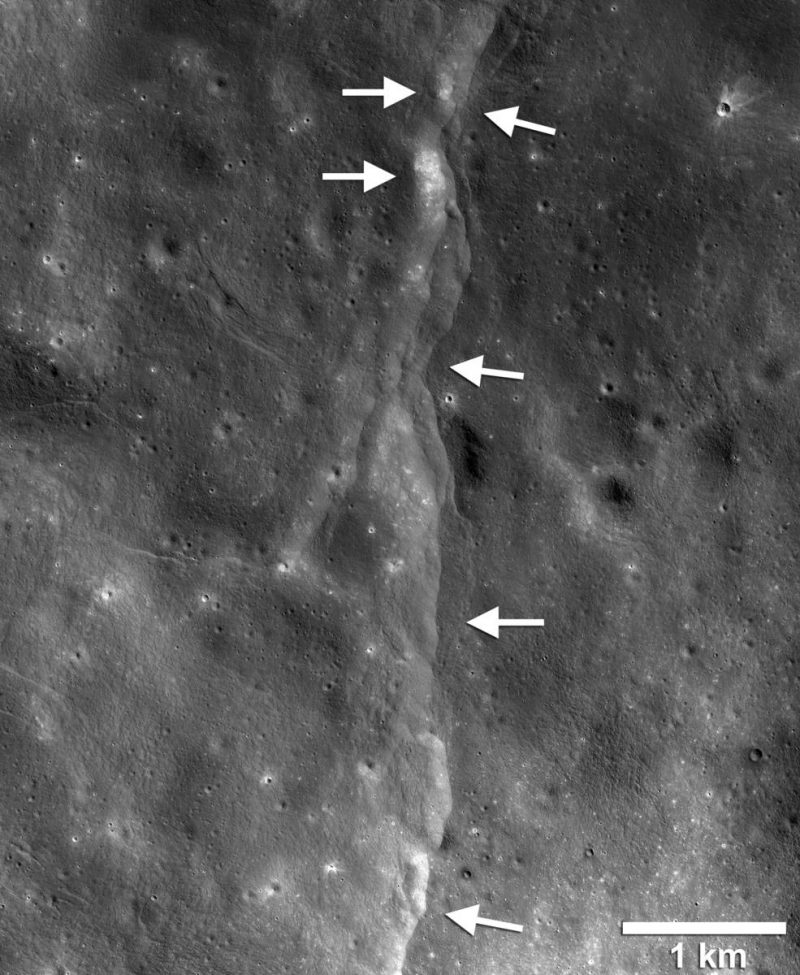 Lunar landscape from orbit with a lighter line down the middle. Arrows point to spots along the line.
