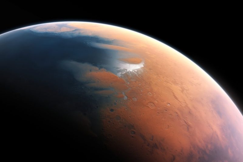 Orbital view of part of Mars with blue ocean to the left, the rest reddish tan with a few craters.