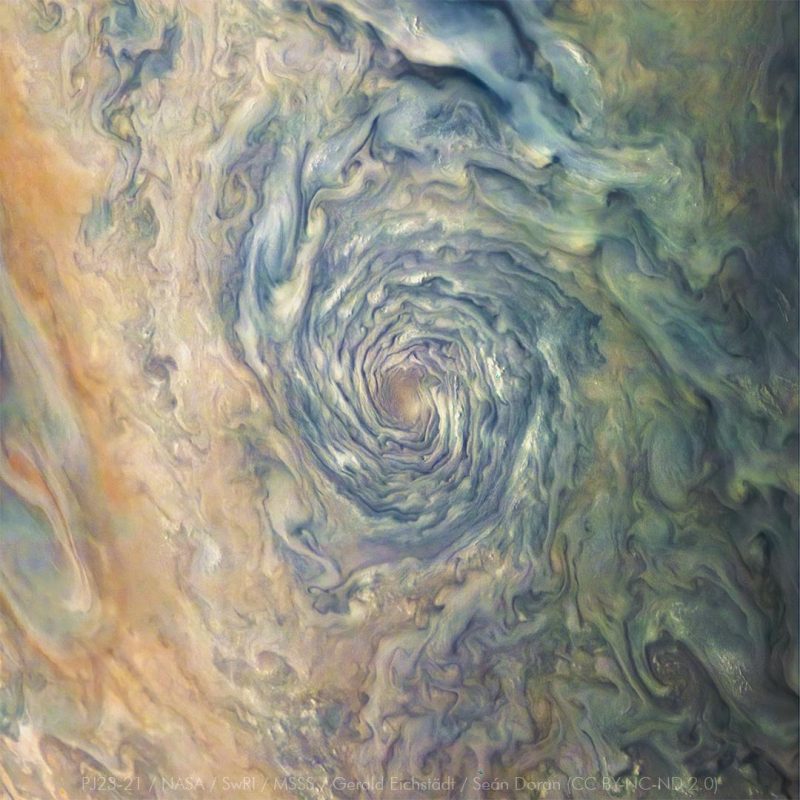 A swirling blue and white hurricane-like vortex on Jupiter.