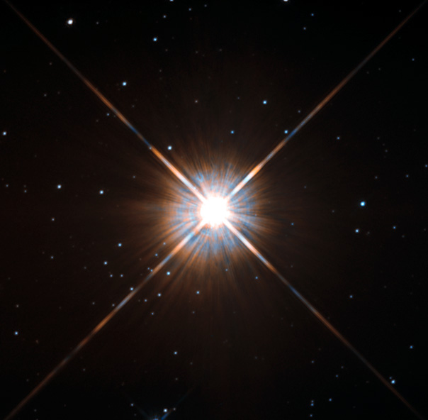 Bright star with four rays caused by lens effect, with fainter background stars.