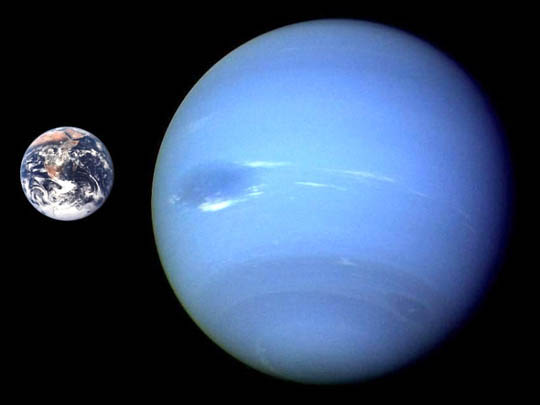 Small Earth next to large blue Neptune on black background.